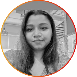 Black-and-white portrait of a woman with shoulder-length hair looking at the camera in an indoor office setting.
